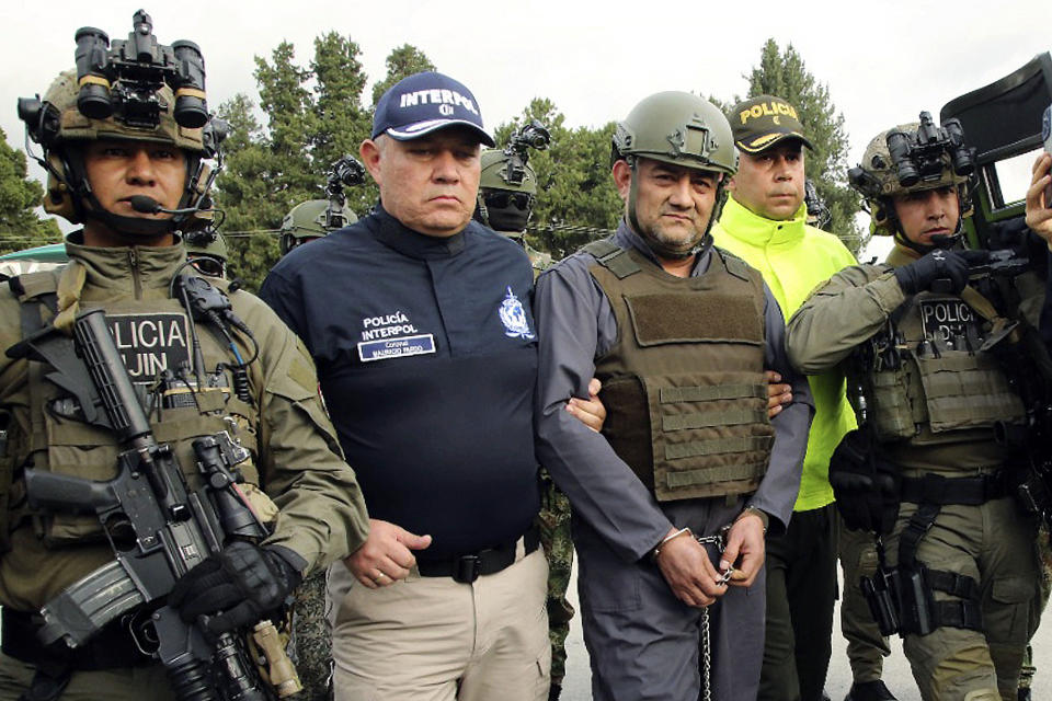 FILE — In this photo released by the Colombian Presidential Press Office, May 4, 2022, police escort Dairo Antonio Usuga, front row second from right, also known as "Otoniel," leader of the violent Clan del Golfo cartel, prior to his extradition to the U.S., at a military airport in Bogota, Colombia. Usuga, 51, pleaded guilty Wednesday, Jan. 25, 2023, to U.S. smuggling charges, admitting that he led a cartel and paramilitary group that trafficked in cocaine and deadly violence. (Colombian Presidential Press Office via AP, File)