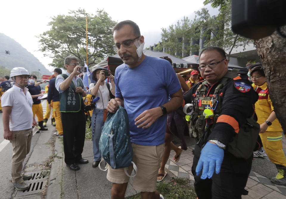 A trapped tourist of Taroko National Park walks to an ambulance after being rescued in Hualien County, eastern Taiwan, Thursday, April 4, 2024. Rescuers are searching for dozens of people still missing a day after Taiwan’s strongest earthquake in a quarter century. (AP Photo/Chiang Ying-ying)