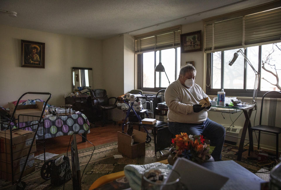 Michael Tokar packs up the apartment of his father, David Tokar, after he died from complications from coronavirus, in the Brooklyn borough of New York, Sunday, April 12, 2020. "I miss him. I like to call him sometimes. Ask him what you need, what you want, sometimes just to keep him busy," said Tokar of his 92-year-old father who collected stamps and liked to go to the casino. "I know he was old man and I was prepared that one day he'd pass away. But I wasn't ready for this. I'm not ready now." (AP Photo/David Goldman)