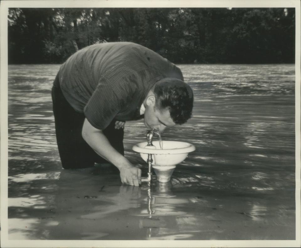 1964: More than knee deep in water, Harlan Krubsack bends over to drink from a bubbler in the Menomonee River Parkway in Wauwatosa on July 18, 1964. The river overflowed its banks after a storm dropped more than 4 inches of rain on the Milwaukee area in an 18-hour period. This photo was on the front page of the July 19, 1964, Milwaukee Journal.