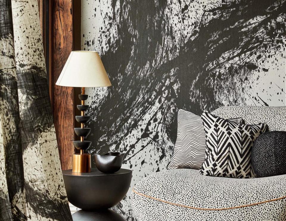 Shown as a curtain sheer and a wallcovering, Enigmatic in the Japanese Ink colorway brings calligraphic splatters to a space. A performance velvet, Fawn in Dalmatian plushly upholsters the love seat. In Black Earth against a pale linen ground, the embroidered motif of the central Thalia throw pillow evokes rows of arrow tails
