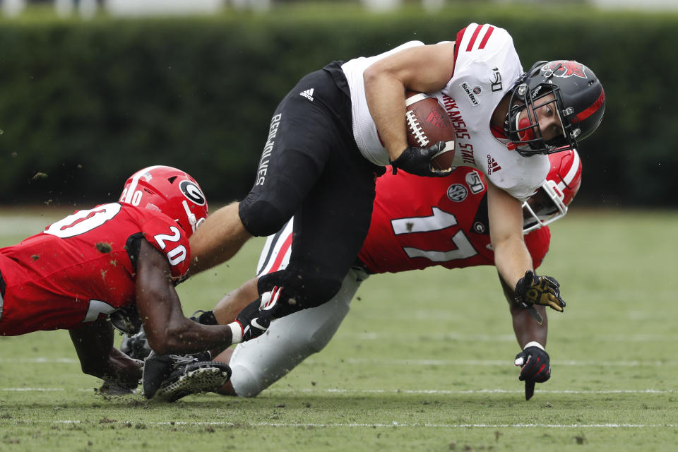 Arkansas State running back Ryan Graham (18) is brought down by Georgia defenders J.R. Reed (20) and Nakobe Dean (17) In the first half of an NCAA college football game Saturday, Sept. 14, 2019, in Athens, Ga. (AP Photo/John Bazemore)