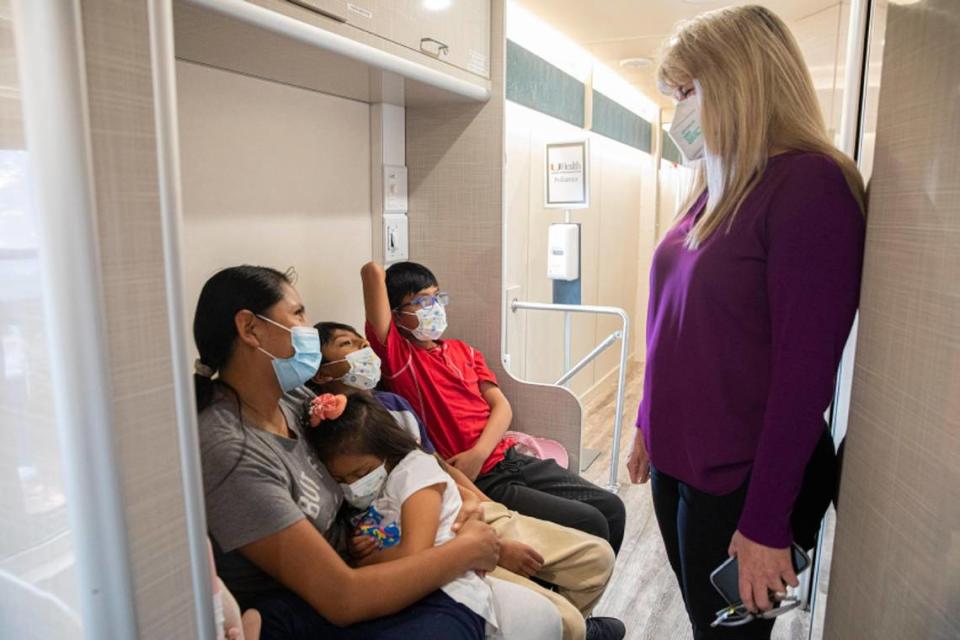 Dr. Lisa Gwynn, right, a University of Miami pediatrician and president of the Florida chapter of the American Academy of Pediatrics, speaks to Julie Machaca (left) and her children (L-R) Saory Betalleluz, 5, Diego Betalleluz, 9, and Cyd Betalleluz, 12, before getting vaccinated at the University of Miami Pediatric Mobile Clinic in Homestead on Friday, June 24, 2022. On Monday, the mobile clinic will begin offering COVID-19 vaccines to children under 5, which the FDA and CDC recently authorized for emergency use.