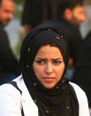 In this Tuesday, Sept. 18, 2018 photo, Hajar Youssif, an Iraqi activist and volunteer medic, who was kidnapped, beaten and threatened for attending protests, sits with protesters in Basra, Iraq. Youssif said the beating left her shaken and that threats continue, but she won’t be deterred. Activists say powerful Iranian-backed militias that control Iraq’s oil capital of Basra have waged a campaign of intimidation and arbitrary arrests to silence protests aimed at poor government services and Tehran’s outsized influence in the region. (AP Photo/Nabil al-Jurani)