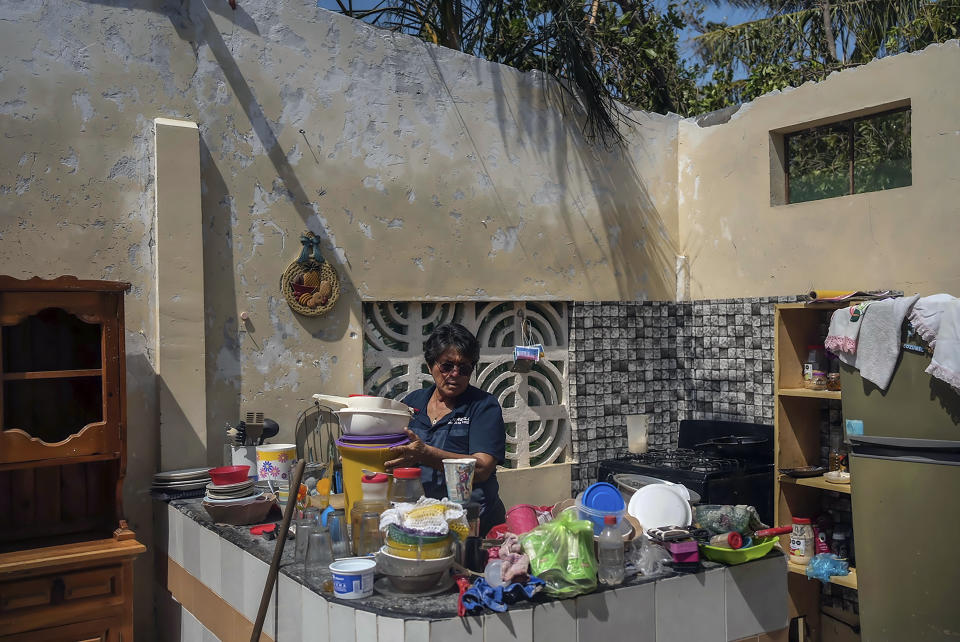 Estela Sandoval Díaz acomoda las cosas en su cocina días después de que su vivienda quedó destrozada por el paso del huracán Otis, en Acapulco, México, el viernes 27 de octubre de 2023. (AP foto/Félix Marquez)