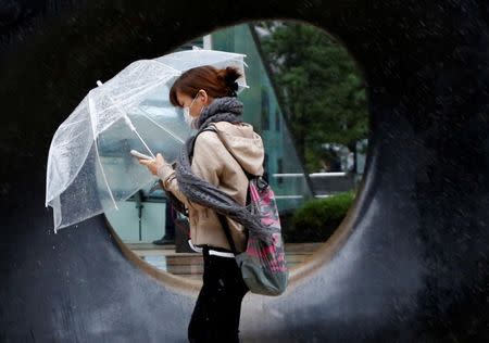 A woman walks in heavy rain and wind as Typhoon Lan approaches Japan's mainland, in Tokyo, Japan, October 22, 2017. REUTERS/Issei Kato