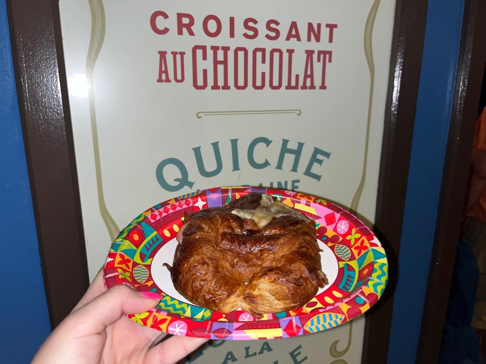 hand holding croissant sandwich from epcot