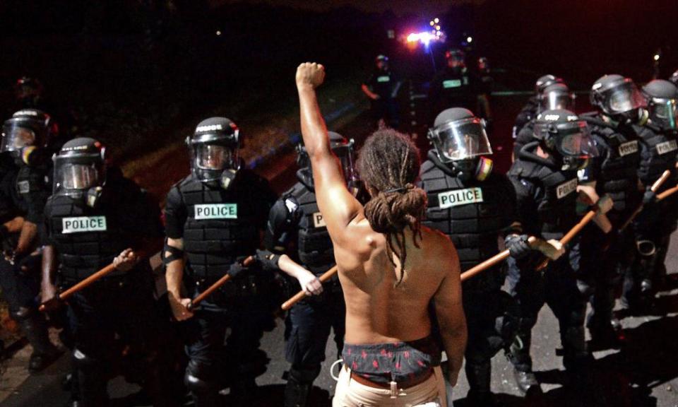 Braxton Winston stands with his left arm and fist clenched as Charlotte-Mecklenburg police officers form a line in Charlotte on 20 September 2016.