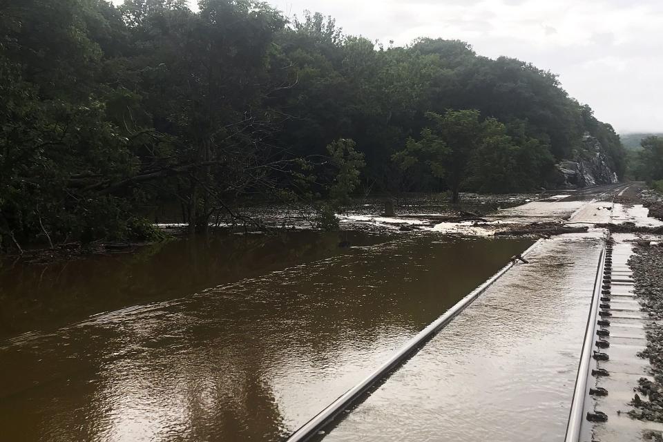 In this photo provided by the Metropolitan Transit Authority, water flows over the Metro North train tracks along the Hudson River during a flash flood, Sunday, July 9, 2023, near Manitou, N.Y. Heavy rain has washed out roads and forced evacuations in the Northeast as more downpours were forecast throughout the day, Monday. (Courtesy of the MTA via AP)