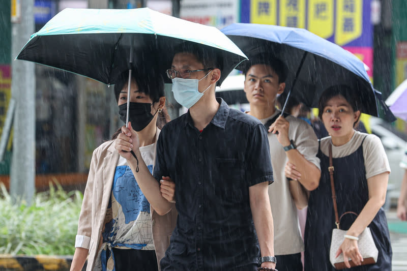 12縣市大雨特報（3） 午後對流旺盛，中央氣象署9日針對12縣市發布大雨 特報。圖為新北市中午出現短暫陣雨，民眾撐傘遮 雨。 中央社記者鄭清元攝  113年6月9日 