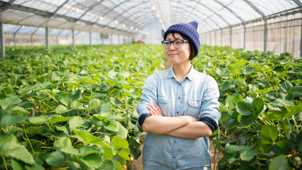 Portrait of a confident small business owner stood inside her farm with her arms crossed.