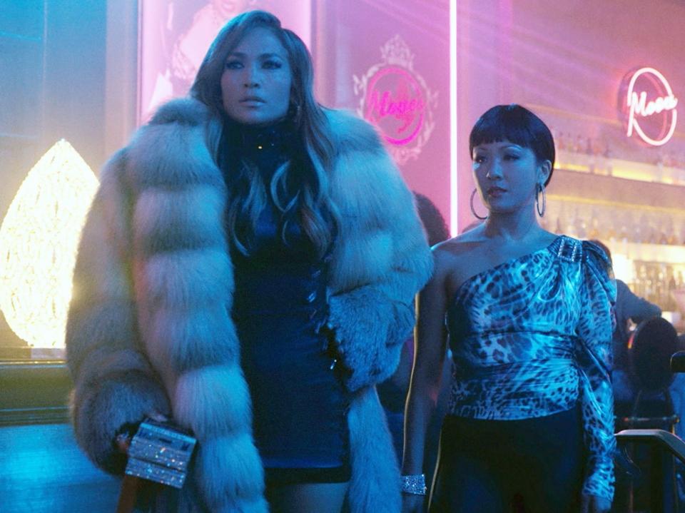 Jennifer Lopez wears a fur coat next to Constance Wu at the strip club