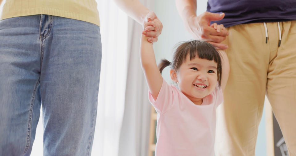 closeup view of asian parents leading children learning to walk