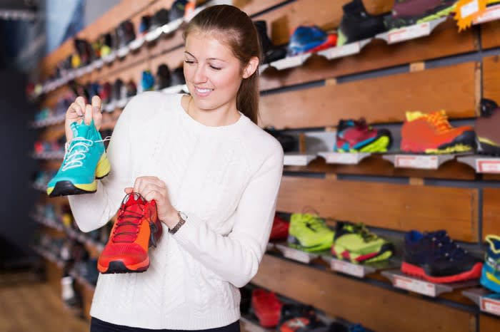 A young woman shops for sneakers.