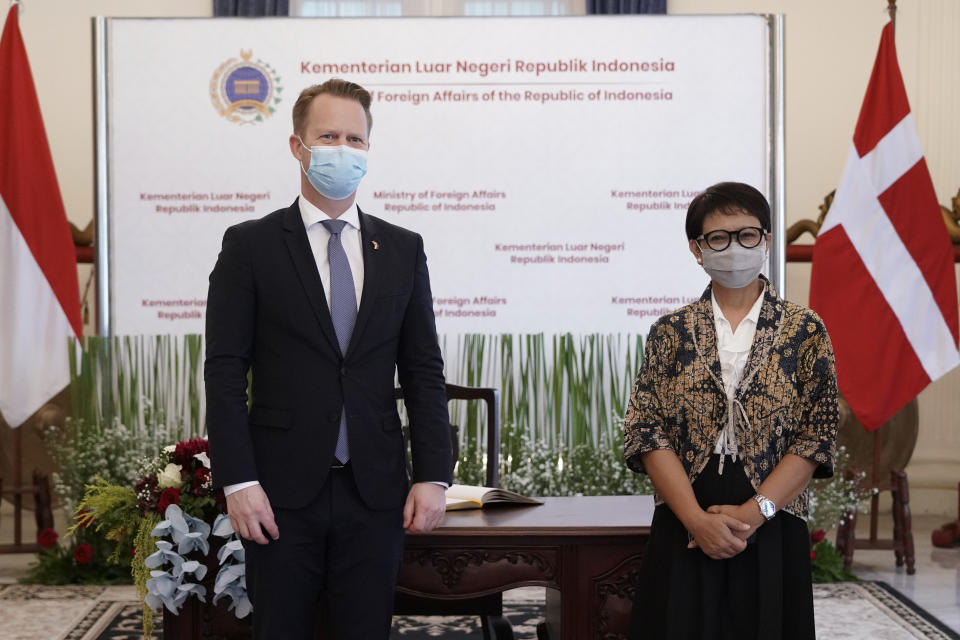 In this photo released by Indonesian Ministry of Foreign Affairs, Denmark's Foreign Minister Jeppe Kofod, left, and his Indonesian counterpart Retno Marsudi pose for photographers during their meeting in Jakarta, Indonesia, Monday, Nov. 22, 2021. (Indonesian Ministry of Foreign Affairs via AP)