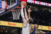 Wake Forest forward Andrew Carr, left, puts the ball in in front of Notre Dame forward Kebba Njie during the first half of an NCAA college basketball game in the second round of the Atlantic Coast Conference tournament, Wednesday, March 13, 2024, in Washington. (AP Photo/Susan Walsh)