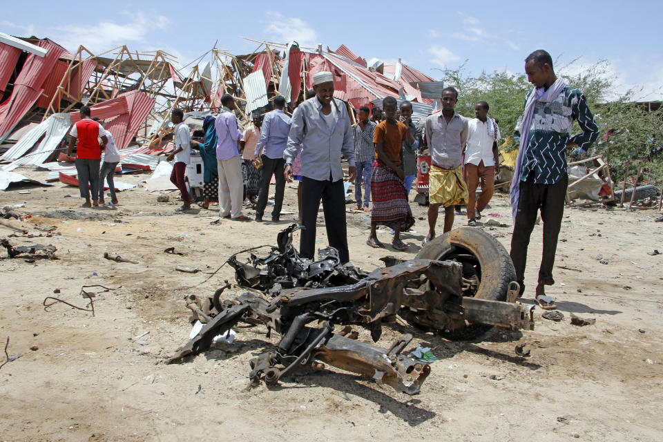 Somalis watch the wreckage of the car bomb after an attack on a European Union military convoy in the capital Mogadishu, Somalia Monday, Sept. 30, 2019. A Somali police officer says a suicide car bomber has targeted a European Union military convoy carrying Italian military trainers in the Somali capital Monday. (AP Photo/Farah Abdi Warsameh)