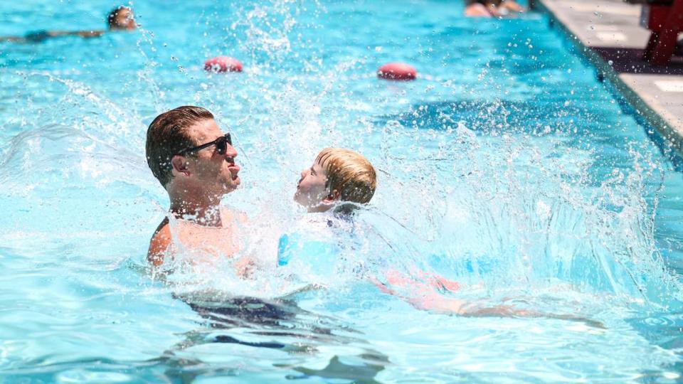 Grant Craton catches his son Finn, 4, as he dives into the Templeton pool, run by San Luis Obispo County Parks and Recreation. Temperature read 109 degrees in the pool parking lot on July 5, 2024.