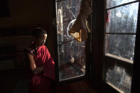 THIMPHU, BHUTAN - OCTOBER 18: A novice Bhutanese monk looks out the window after hours of prayer waiting for class to be over at the Dechen Phodrang monastery October 18, 2011 in Thimphu, Bhutan. About 375 monks reside at the government run monastery that also doubles as a child care facility for under priviledged and orphaned males. The monks average about 10 hours of study a day waking up at 5:00am. Mahayana Buddhism is the state religion, although in the southern areas many citizens openly practice Hinduism. Monks join the monastery at six to nine years of age and according to tradition many families will send one son into the monk hood. They learn to read chhokey, the language of the ancient sacred texts, as well as Dzongkha and English. (Photo by Paula Bronstein/Getty Images)