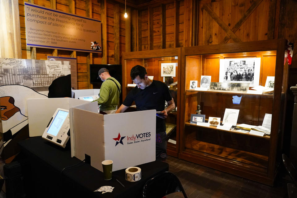 Voters mark their ballots in the Indiana primary election among the display cases at the Benjamin Harrison Presidential Site in Indianapolis, Tuesday, May 3, 2022. The site was the former home of Harrison, the 23rd President of the United States from 1889 to 1893. (AP Photo/Michael Conroy)