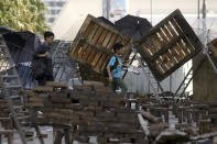 People walk through barricades built by protestors near the Hong Kong Polytechnic University in Hong Kong, Saturday, Nov. 16, 2019. Rebellious students and anti-government protesters abandoned their occupation of at least one major Hong Kong university after a near weeklong siege by police, but some other schools remained under control of demonstrators on Saturday. (AP Photo/Achmad Ibrahim)