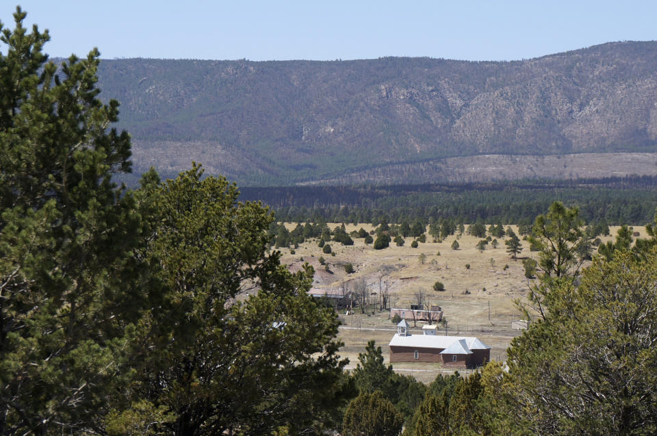 The 1840s church of San Geronimo is seen against the mountains charred by last year's massive wildfire in a remote valley west of Las Vegas, New Mexico, Saturday, April 15, 2023. The historic adobe church in a nearly abandoned village has massive cracks in its earthen walls and is in danger of collapsing, as are many remote chapels in this rural area with dwindling congregations and chronic poverty. (AP Photos/Giovanna Dell'Orto)