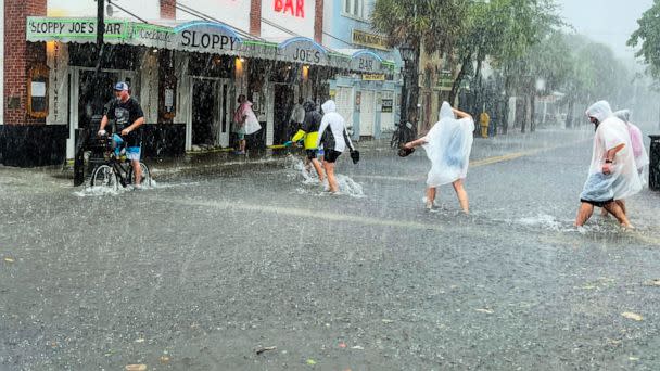 PHOTO: In this July 6, 2021, file photo, determined visitors head for Sloppy Joe's Bar while crossing a flooded Duval Street as heavy winds and rain pass over Key West, Fla., as Tropical Storm Elsa began lashing the Florida Keys. (Rob O'Neal/The Key West Citizen via AP, FILE)