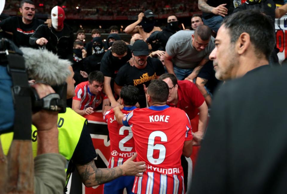 Jose Gimenez and Koke of Atletico Madrid plead with fans after objects are thrown at Thibaut Courtois (Getty Images)