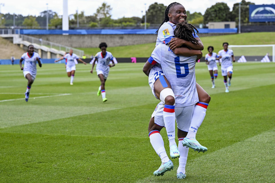 Melchie Dumonay of Haiti is congratulated by teammate Roselord Borgella, top, after scoring her team's first goal during their FIFA women's World Cup qualifier against Chile in Auckland, New Zealand, Wednesday, Feb. 22, 2023. (Andrew Cornaga/Photosport via AP)