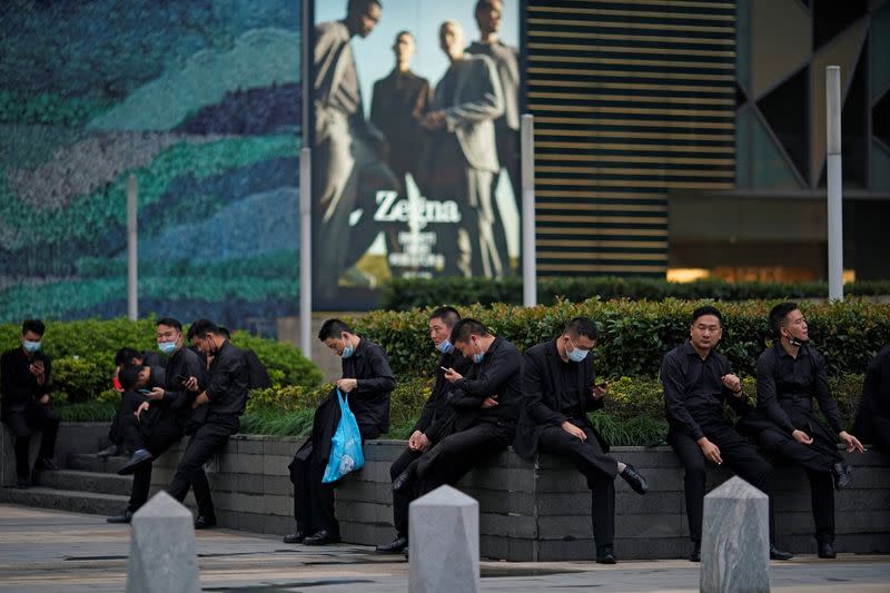 Security guards rest outside a shopping mall at financial district of Lujiazui in Shanghai