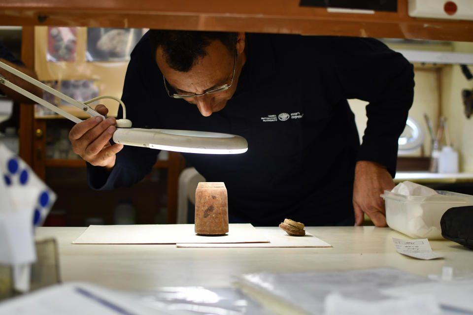 Amir Ganor, head of the Murba'at excavations team, inspects the coins in an ancient wooden box.  (Yoli Schwartz / Israel Antiquities Authority)