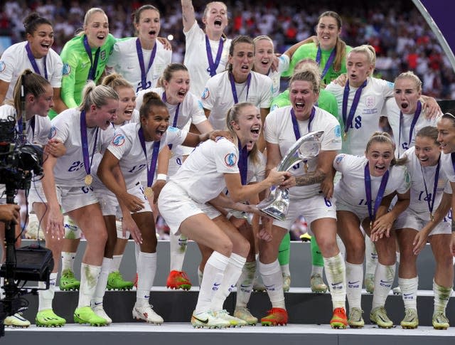 The Lionesses celebrate with a trophy in a team shot after the Euro 2022 final 