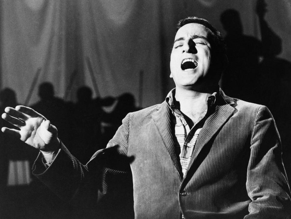 A black-and-white horizontal frame of Tony Bennett singing with his eyes closed.