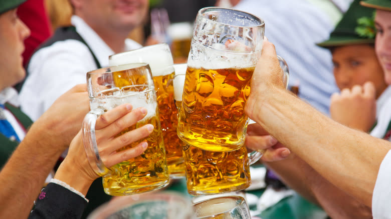 People holding steins of beer 