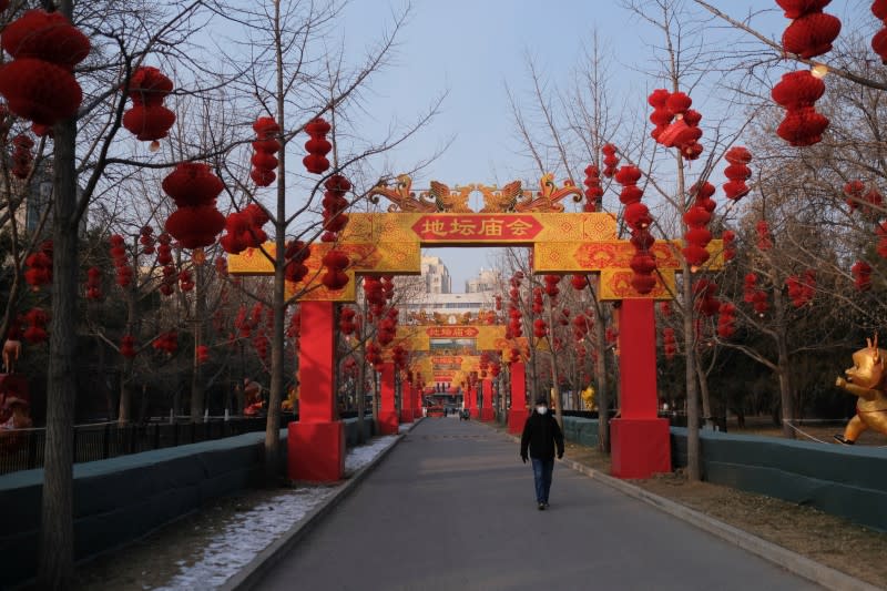 A man wearing a protective mask walks at Ditan Park in Beijing