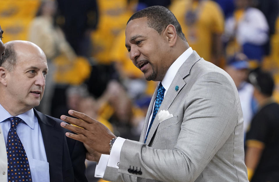 Mark Jackson, right, talks with Jeff Van Gundy before Game 4 of basketball's NBA Finals between the Golden State Warriors and the Toronto Raptors in Oakland, Calif., Friday, June 7, 2019. ABC/ESPN NBA analyst Jackson credits faith, confidence and longtime friendships with Van Gundy and Mike Breen as the main catalysts for his longevity and why he is working his 12th NBA Finals. (AP Photo/Tony Avelar)