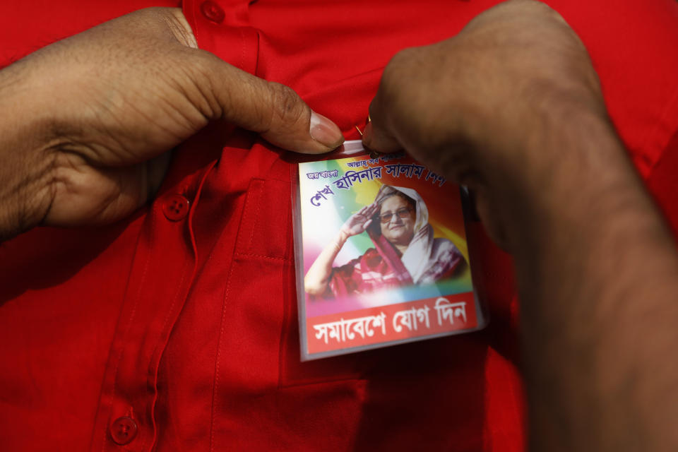 An Awami League political party supporter attaches a badge to the shirt of a fellow supporter during a rally to celebrate the party's overwhelming victory in last month's election in Dhaka, India, Saturday, Jan. 19, 2019. (AP Photo)