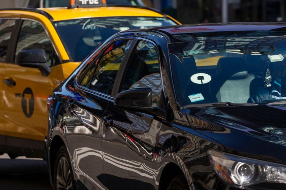 Uber car next to yellow taxi