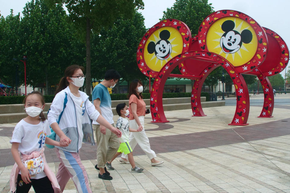 Visitors walk around the Disneyland theme park in Shanghai, China, Monday, May 11, 2020. Visitors wearing face masks streamed into Shanghai Disneyland as China’s most prominent theme park reopened Monday in a new step toward rolling back anti-coronavirus controls that shut down its economy. (AP Photo/Sam McNeil)