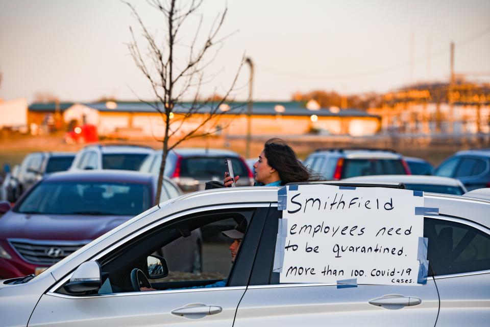 A woman records a demonstration on her phone through the sunroof of her car as workers at Smithfield Food in Sioux Falls, South Dakota, protest against unsafe working conditions in April 2020.