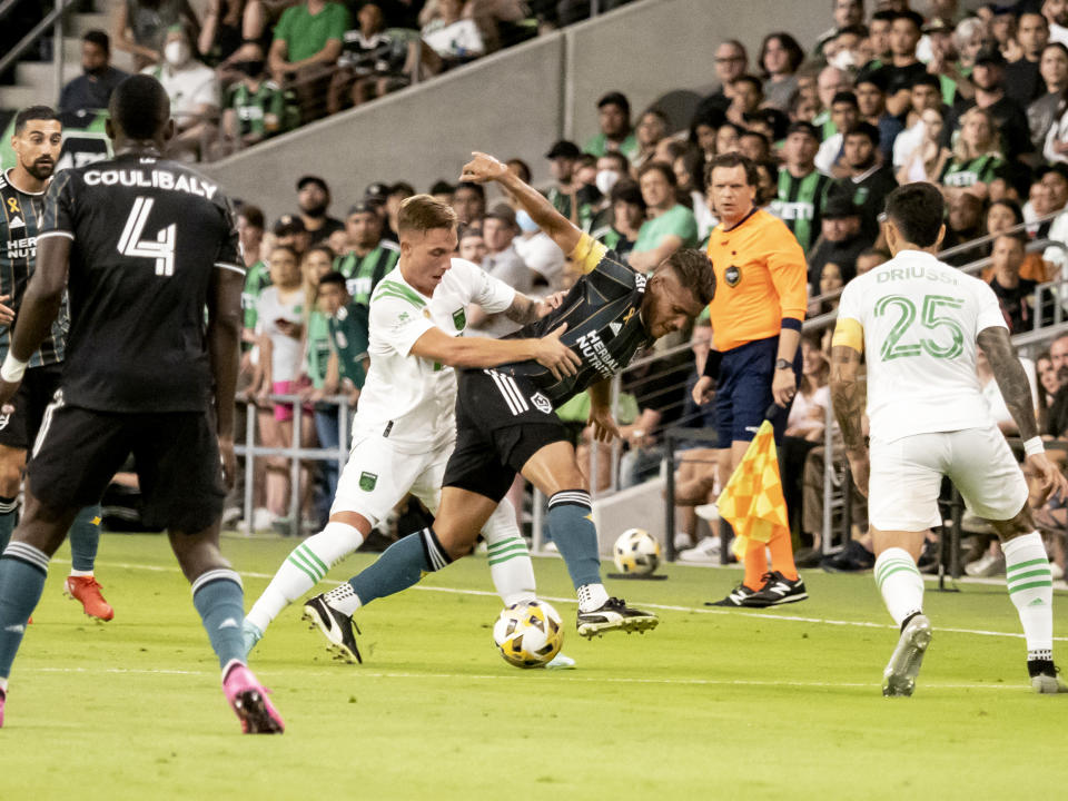 Austin FC defender Zan Kolmanic, left, pushes LA Galaxy midfielder Jonathan dos Santos, right, during the first half of an MLS soccer match, Sunday, Sept. 26, 2021, in Austin, Texas. (AP Photo/Michael Thomas)