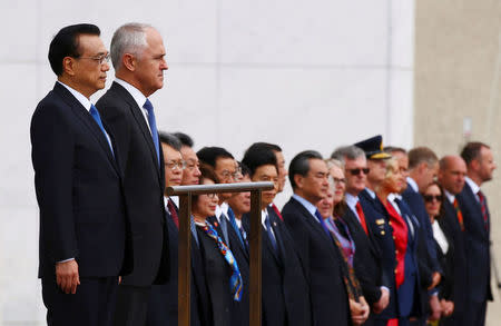 Chinese Premier Li Keqiang and Australia's Prime Minister Malcolm Turnbull stand for national anthems before an official welcoming ceremony at Parliament House in Canberra, Australia, March 23, 2017. REUTERS/David Gray