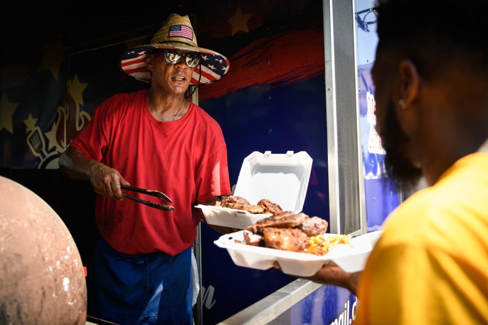 ArRee Bateman, of Red, White & Blue BBQ, dishes up plates for customers at the 2nd annual Black BBQ Cook Off on Saturday, Aug. 19, 2023, at Murchison Marketplace.