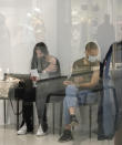 People wait for their turn in a vaccination center in a city mall in Kyiv, Ukraine, Thursday, Oct. 21, 2021. Coronavirus infections and deaths in Ukraine have surged to all-time highs amid a laggard pace of vaccination, which is one of the lowest in Europe. (AP Photo/Efrem Lukatsky)