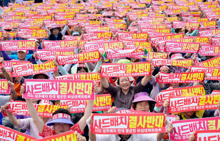 Residents chant slogans during a protest against goverments decision on deploying a U.S. THAAD anti-missile defense unit in Seongju, South Korea, July 13, 2016. The banner reads "Desperately oppose deploying THAAD in Seongju". Lee Jong-hyun/News1 via REUTERS