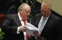 Toronto Mayor Rob Ford and his brother, city councillor Doug Ford,attend a special council meeting to remove many of his powers Monday in Toronto.