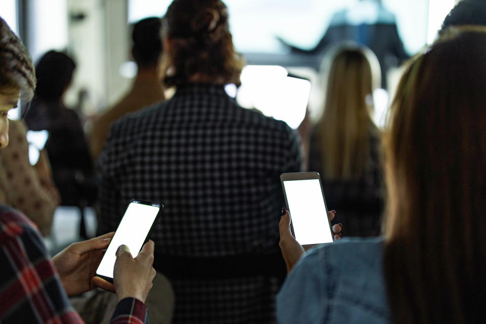 A group of people with cellphones