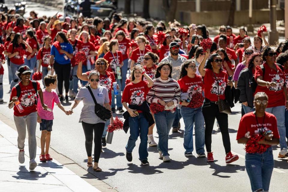 Thousands of women and members of the Girls Inc. of Tarrant County march down Cherry Street for the 2023 Day of the Girl march at Burnett Park in Fort Worth on Friday.