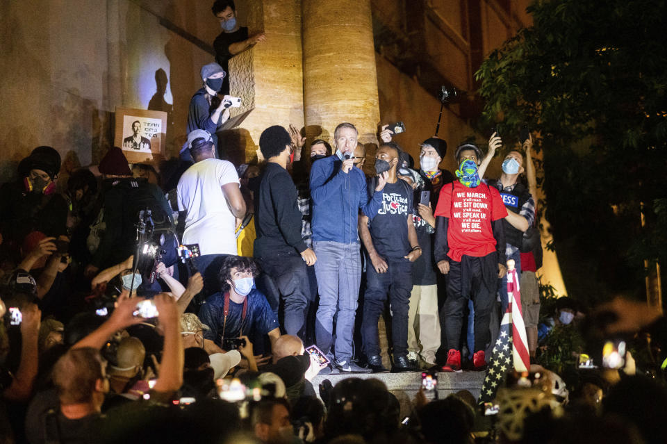 Portland Mayor Ted Wheeler speaks to Black Lives Matter protesters on Wednesday, July 22, 2020, in Portland, Ore. Late Wednesday Wheeler joined protesters at the front of the crowd and was hit with chemical irritants several times by federal officers dispersing demonstrators. (AP Photo/Noah Berger)