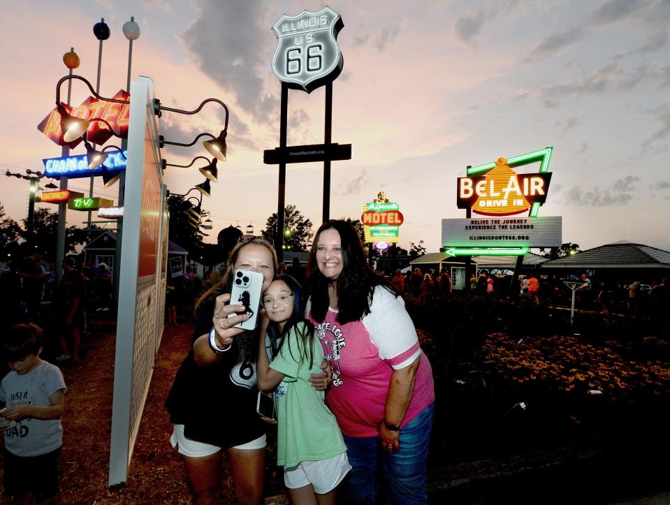 Katie Decosta of Mokena, left, and her daughter Lily, 11, center, take a selfie with Denise Kimberly of Naperville at the Route 66 Experience attraction at the Illinois State Fair Grounds Wednesday, July 26, 2023.